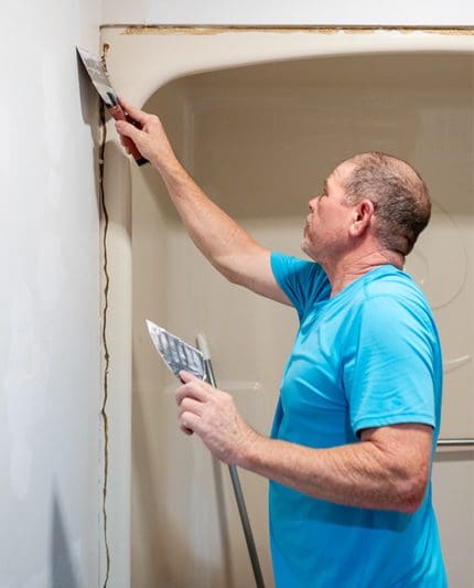 A man in blue shirt holding a spatula.