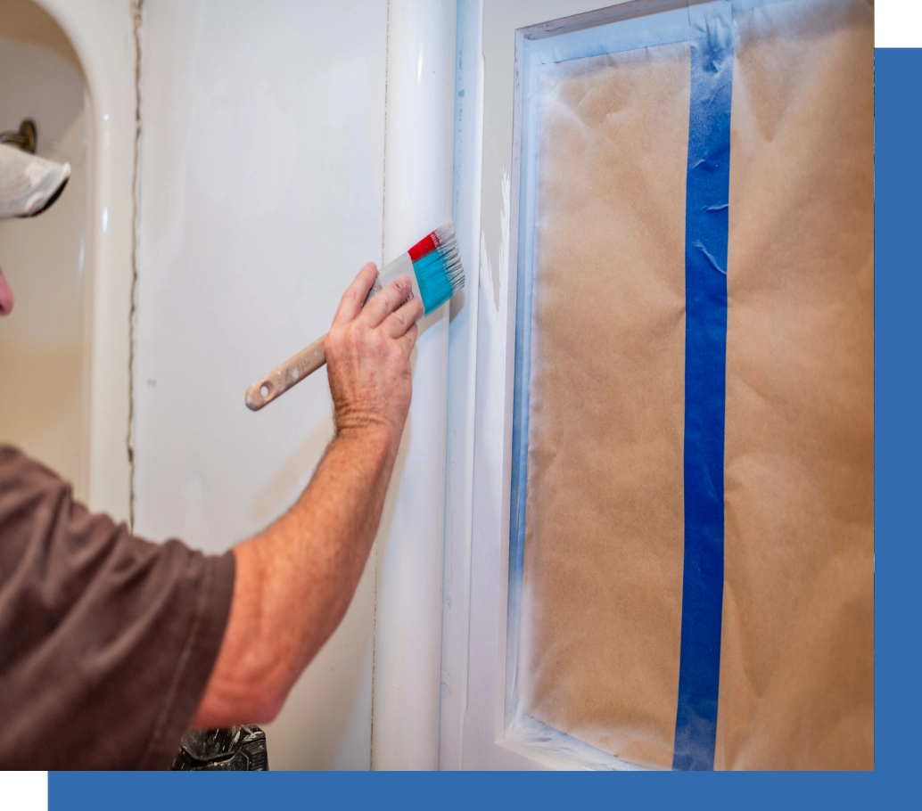 A man painting the wall of his bathroom.