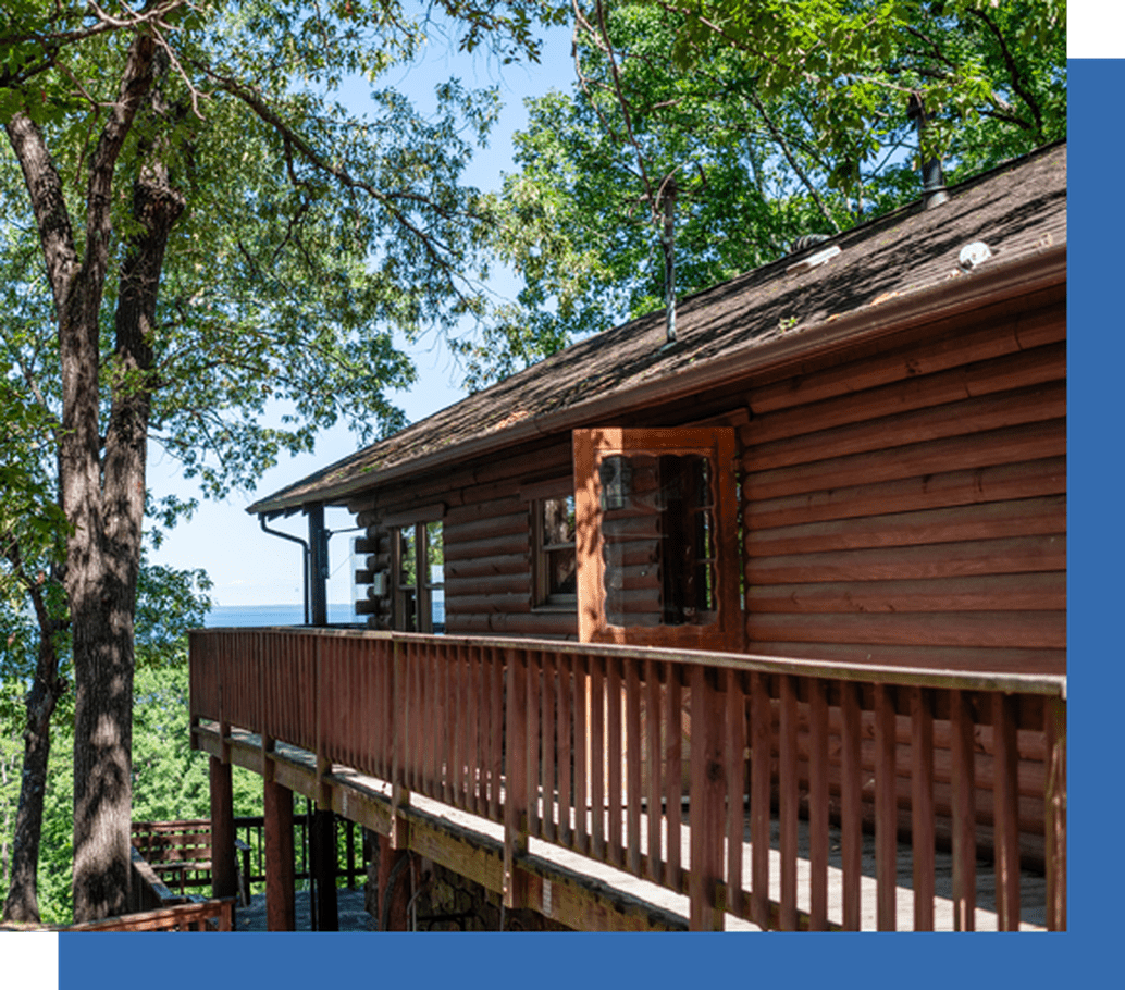 A wooden house with a balcony and a tree