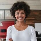 A woman with curly hair smiling for the camera.